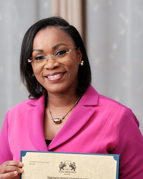 Le Dr Florence Nanga tient son certificat de trichologue de la World Trichology Society