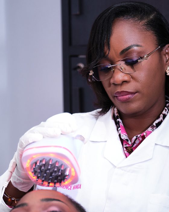 Le Dr Florence Nanga passe une brosse à lumière LED sur le cuir chevelu
